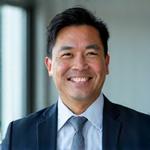 Portrait of Michael Tan, a financial analyst, with a confident, energetic expression.
